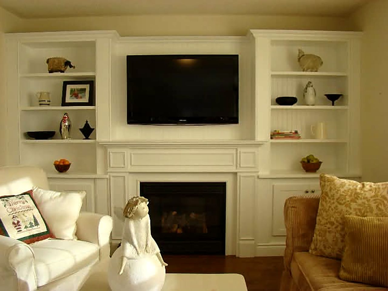 White built-in shelving and cabinets around a fireplace and television