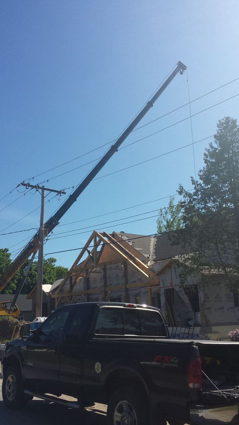 Crane lifting timbers onto a porch frame
