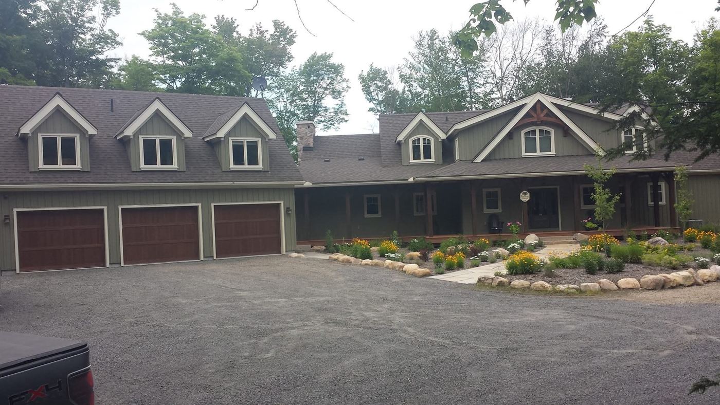 Front of the lake house with its three door garage
