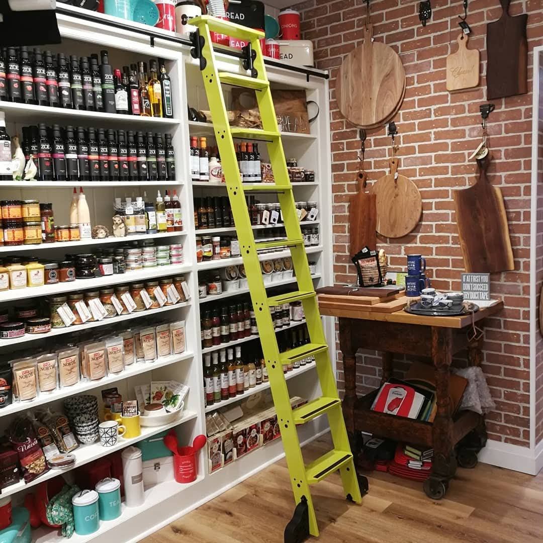 Lime green rolling ladder on white pantry shelving