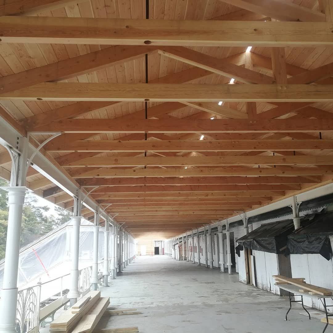 Long covered walkway under new timber trusses and a wood ceiling