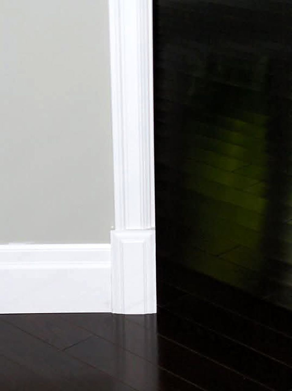 Close view of white casing meeting a tall baseboard